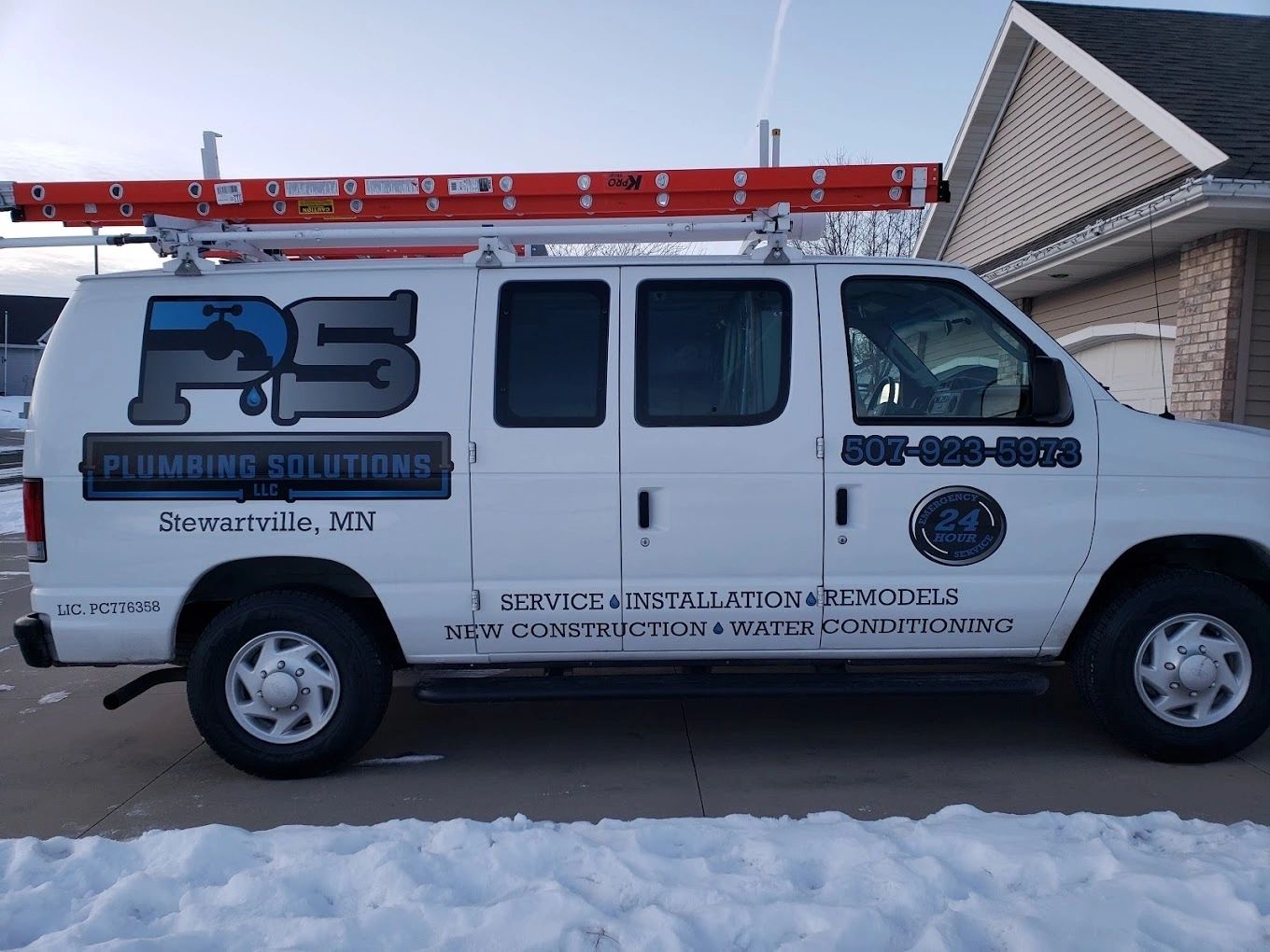 The Plumbing Solutions van parked in snow, with the logo, town and phone number on the side.